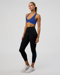 Woman wearing Rep Ultra High-Rise 7/8 Legging Pockets - Black-Electric Indigo | Model:Evie | Size:S
