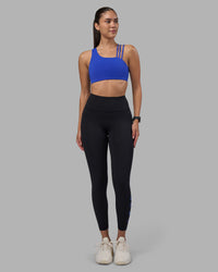 Woman wearing Rep Ultra High-Rise 7/8 Legging Pockets - Black-Power Cobalt | Model:Rhiley | Size:S