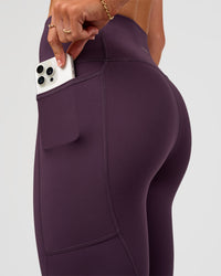 Woman wearing Rep Ultra High-Rise 7/8 Legging Pockets - Midnight Plum-Marshmallow | Model:Emelia | Size:S