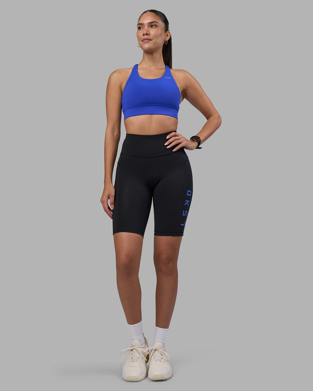 Woman wearing Rep Ultra High-Rise 9&quot; Short Pockets - Black-Power Cobalt | Model:Rhiley | Size:S