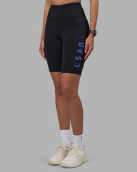 Woman wearing Rep Ultra High-Rise 9" Short Pockets - Black-Power Cobalt | Model:Rhiley | Size:S