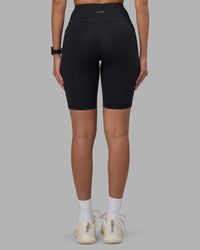 Woman wearing Rep Ultra High-Rise 9" Short Pockets - Black-Power Cobalt | Model:Rhiley | Size:S