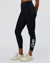 Woman wearing Rep Street Script Ultra High-Rise 7/8 Legging Pockets - Black-White | Model:Rosie | Size:S