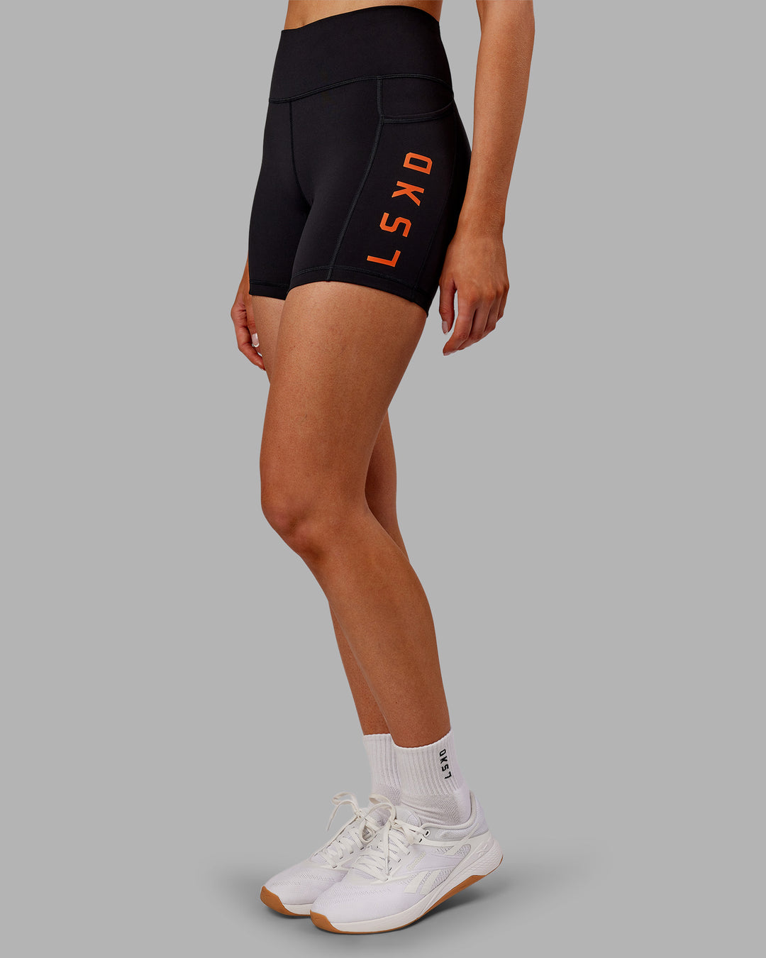 Woman wearing Rep Ultra High-Rise 4&quot; Short Pockets - Black-Ultra Orange | Model:Ella | Size:S
