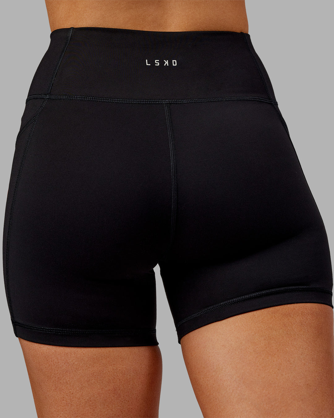Woman wearing Rep Ultra High-Rise 4&quot; Short Pockets - Black-Ultra Orange | Model:Ella | Size:S