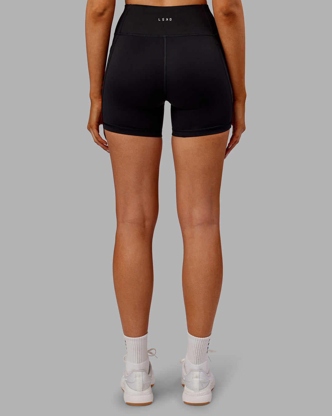 Woman wearing Rep Ultra High-Rise 4&quot; Short Pockets - Black-Ultra Orange | Model:Ella | Size:S