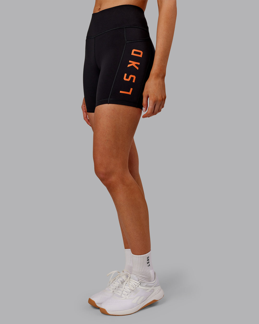 Woman wearing Rep Ultra High-Rise 6&quot; Short Pockets - Black-Ultra Orange | Model:Ella | Size:S