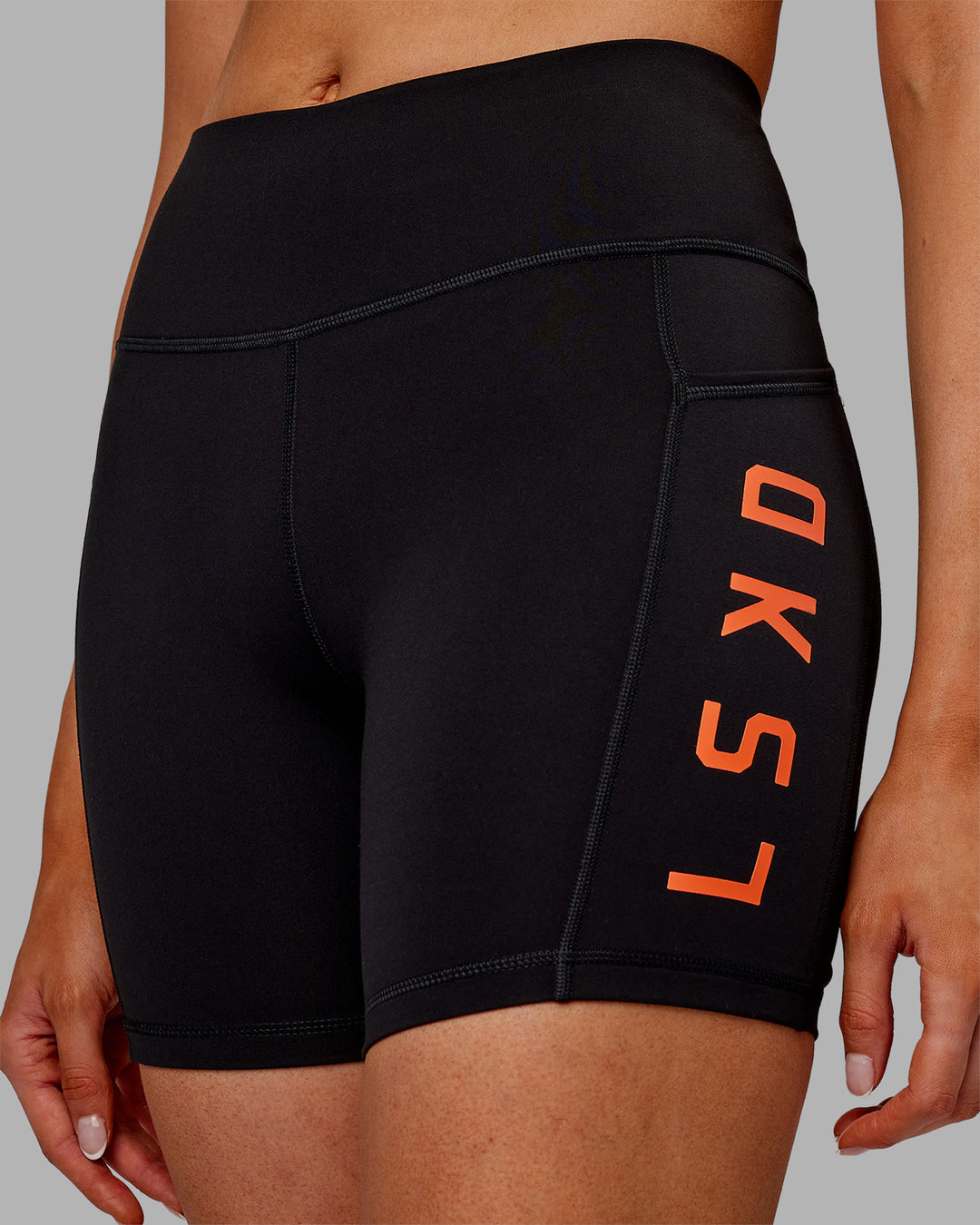 Woman wearing Rep Ultra High-Rise 6&quot; Short Pockets - Black-Ultra Orange | Model:Ella | Size:S