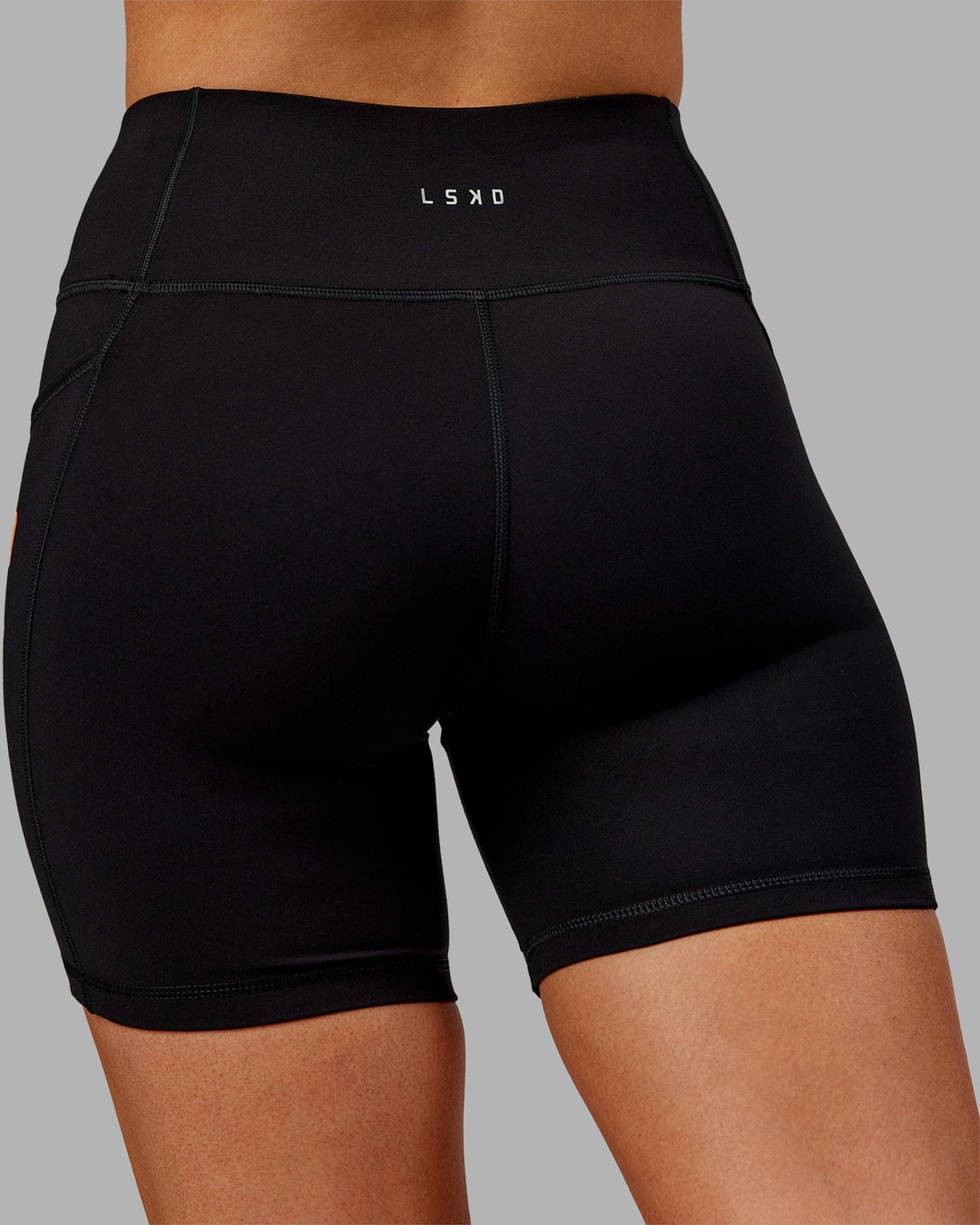 Woman wearing Rep Ultra High-Rise 6&quot; Short Pockets - Black-Ultra Orange | Model:Ella | Size:S