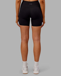 Woman wearing Rep Ultra High-Rise 6" Short Pockets - Black-Ultra Orange | Model:Ella | Size:S