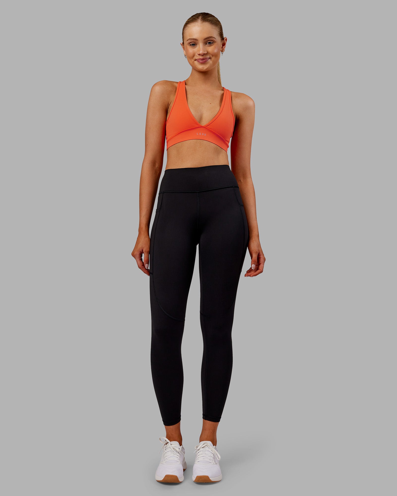 Woman wearing Rep Ultra High-Rise 7/8 Legging Pockets - Black-Ultra Orange | Model:Ella | Size:S