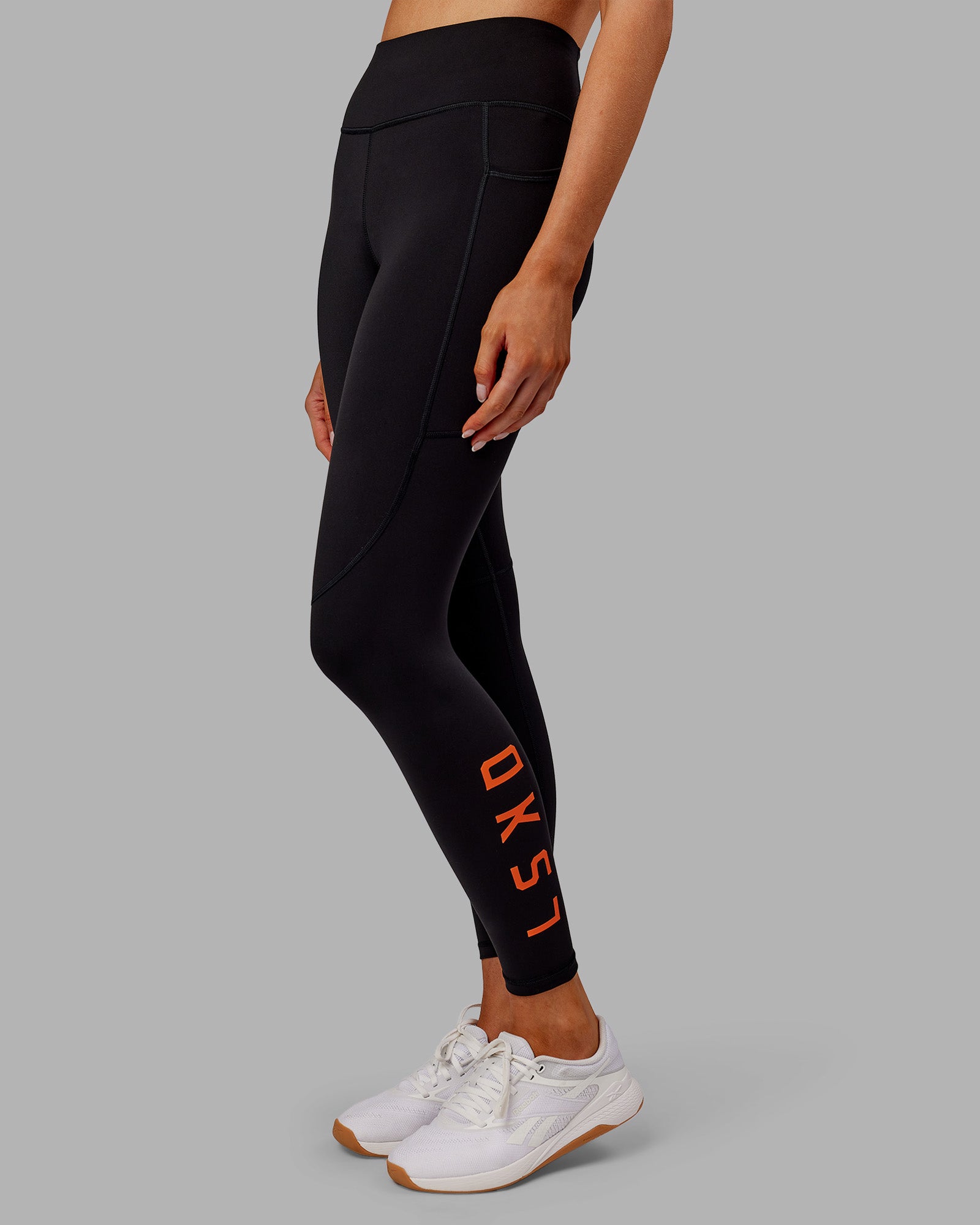 Woman wearing Rep Ultra High-Rise 7/8 Legging Pockets - Black-Ultra Orange | Model:Ella | Size:S