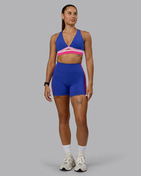 Woman wearing Revitalise Sports Bra - Power Cobalt-Fuchsia Pink