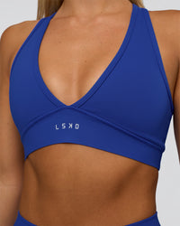 Woman wearing Stamina Sports Bra - Electric Indigo | Set:true | Angle:closeup | Model:Amity | Size:S