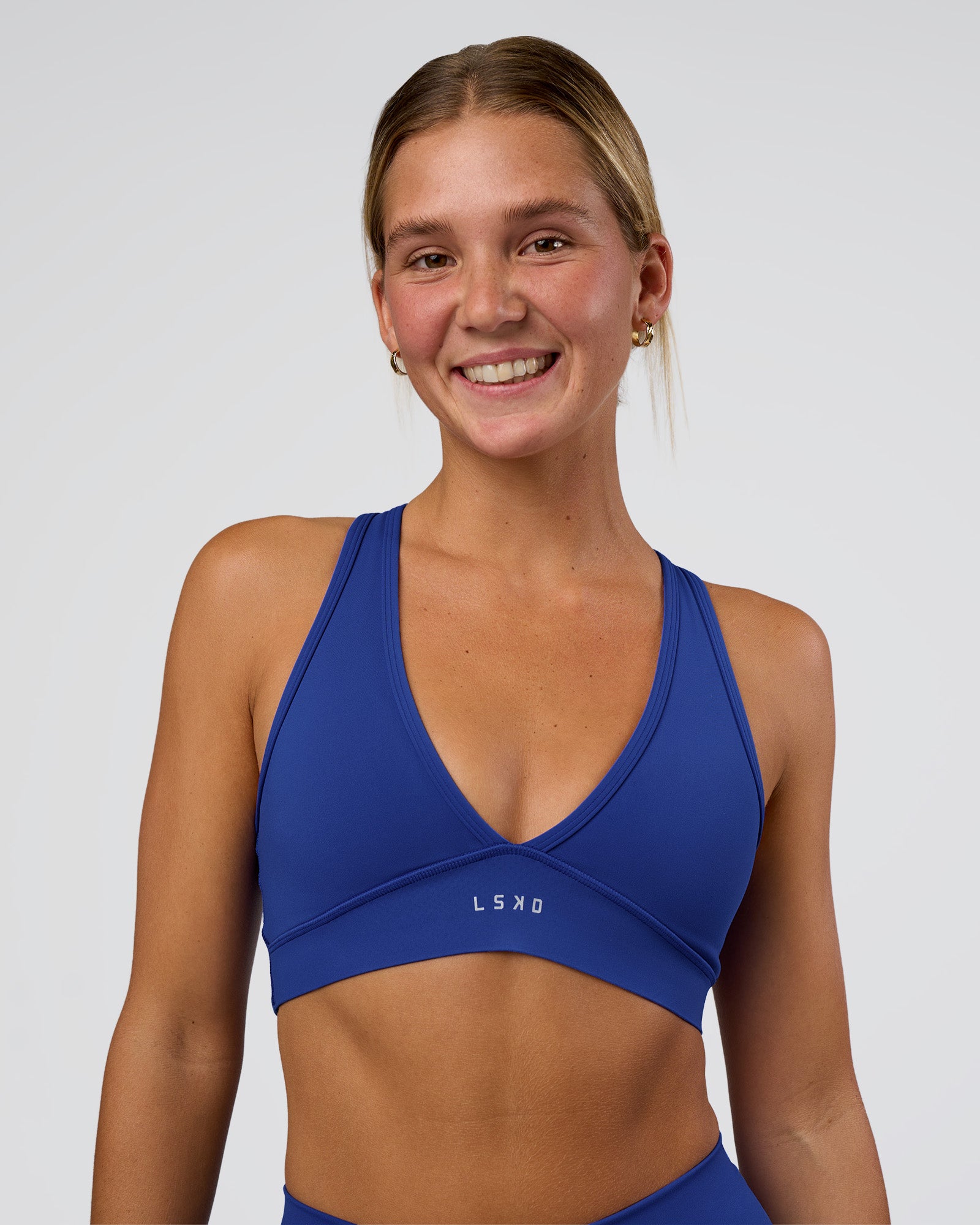 Woman wearing Stamina Sports Bra - Electric Indigo | Set:true | Angle:front | Model:Amity | Size:S