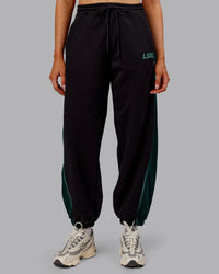 Woman wearing Stitch Up Fleece Sweat Pant - Black/Dark Moss | Model:Ella | Size:S