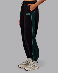 Woman wearing Stitch Up Fleece Sweat Pant - Black/Dark Moss | Model:Ella | Size:S