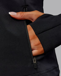 Woman wearing Stride Thermal Zip Through Jacket - Black | Model:Ella | Size:S