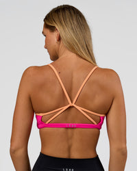Woman wearing Tempo Sports Bra - Ultra Pink-Cantaloupe | Model:Amity | Size:S