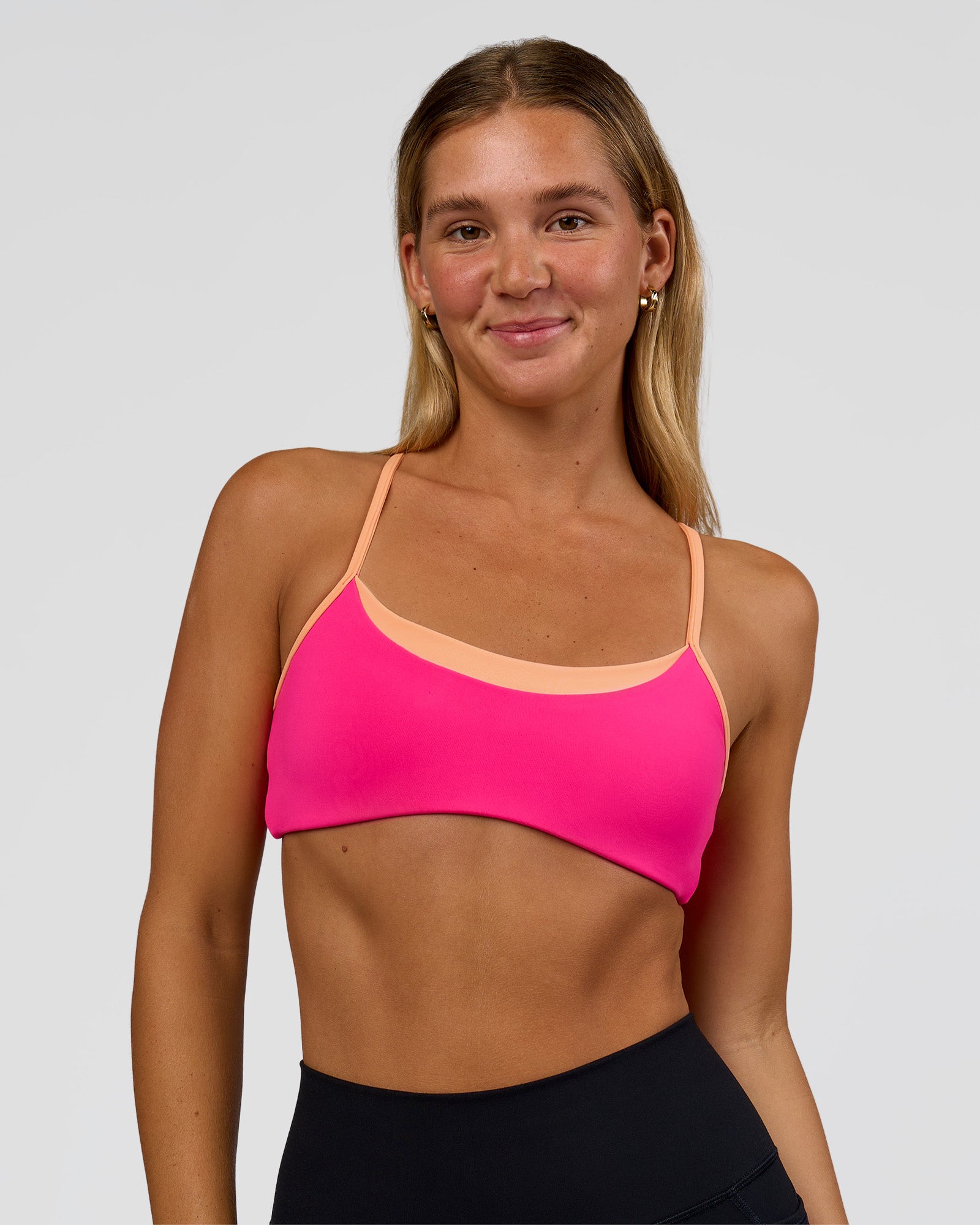Woman wearing Tempo Sports Bra - Ultra Pink-Cantaloupe | Model:Amity | Size:S