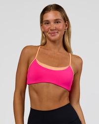 Woman wearing Tempo Sports Bra - Ultra Pink-Cantaloupe | Model:Amity | Size:S