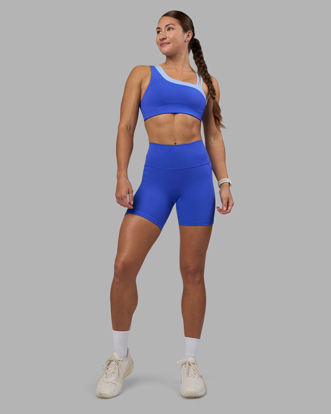 Woman wearing Thrive Asymmetric Sports Bra - Power Cobalt-Open Air | Model:Hannah | Size:S