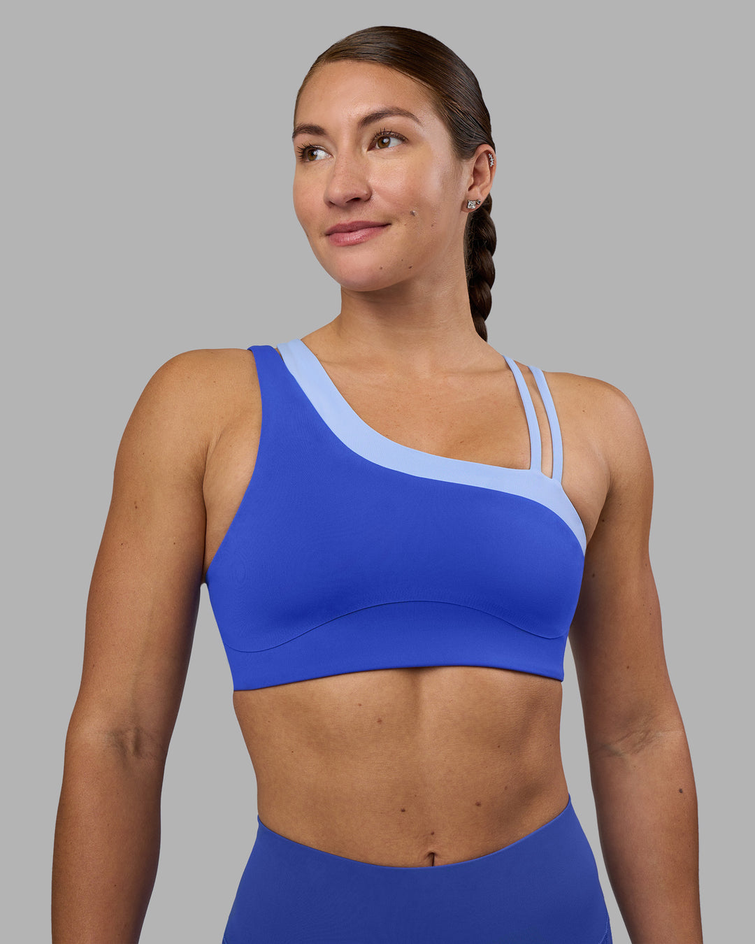 Woman wearing Thrive Asymmetric Sports Bra - Power Cobalt-Open Air | Model:Hannah | Size:S