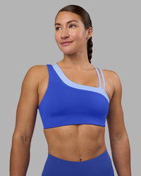 Woman wearing Thrive Asymmetric Sports Bra - Power Cobalt-Open Air | Model:Hannah | Size:S