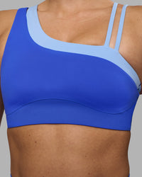 Woman wearing Thrive Asymmetric Sports Bra - Power Cobalt-Open Air | Model:Hannah | Size:S