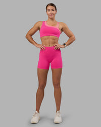 Woman wearing Thrive Asymmetric Sports Bra - Ultra Pink-Candy Pink | Model:Hannah | Size:S