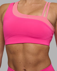 Woman wearing Thrive Asymmetric Sports Bra - Ultra Pink-Candy Pink | Model:Hannah | Size:S