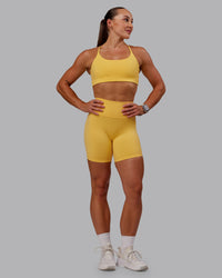 Woman wearing Twist Sports Bra in Banana Cream | Size:S