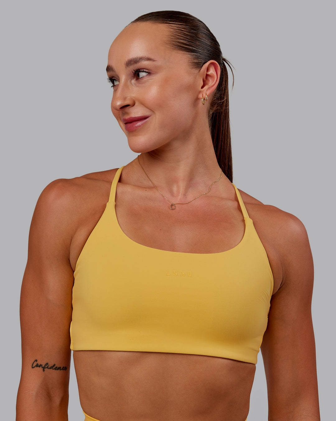 Woman wearing Twist Sports Bra in Banana Cream | Size:S