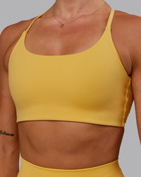 Woman wearing Twist Sports Bra in Banana Cream | Size:S