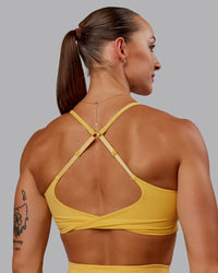 Woman wearing Twist Sports Bra in Banana Cream | Size:S