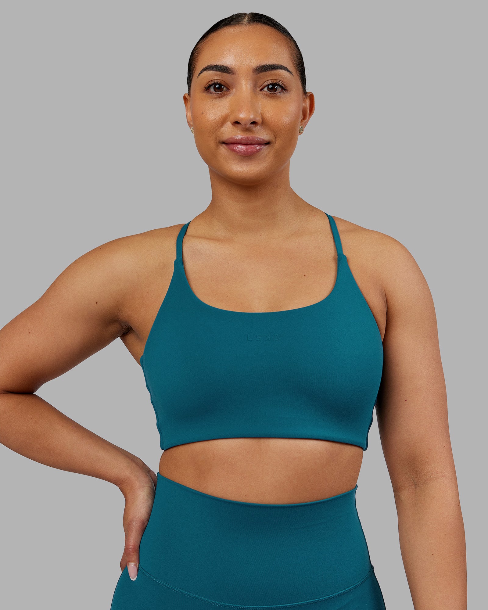 Woman wearing Twist Sports Bra - Blue Coral | Model:Ayla | Size:S