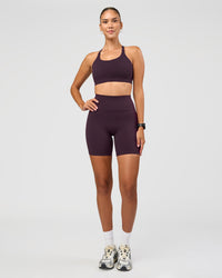 Woman wearing Twist Sports Bra D/DD/E - Midnight Plum | Model:Rhiley | Size:S