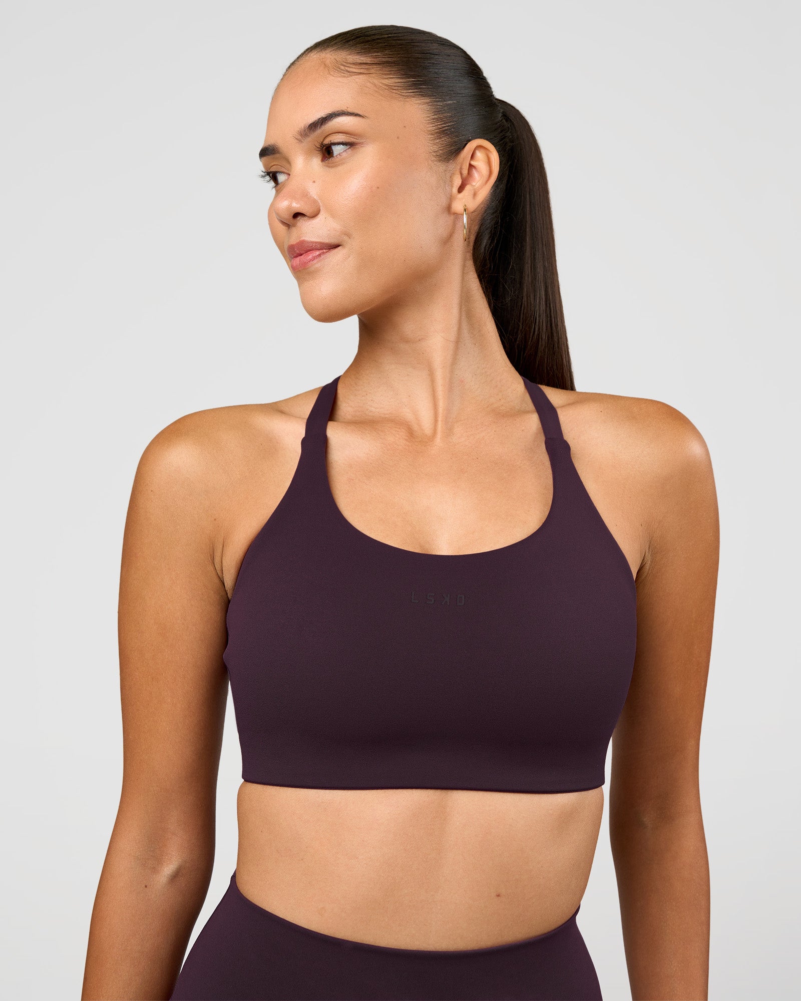 Woman wearing Twist Sports Bra D/DD/E - Midnight Plum | Model:Rhiley | Size:S