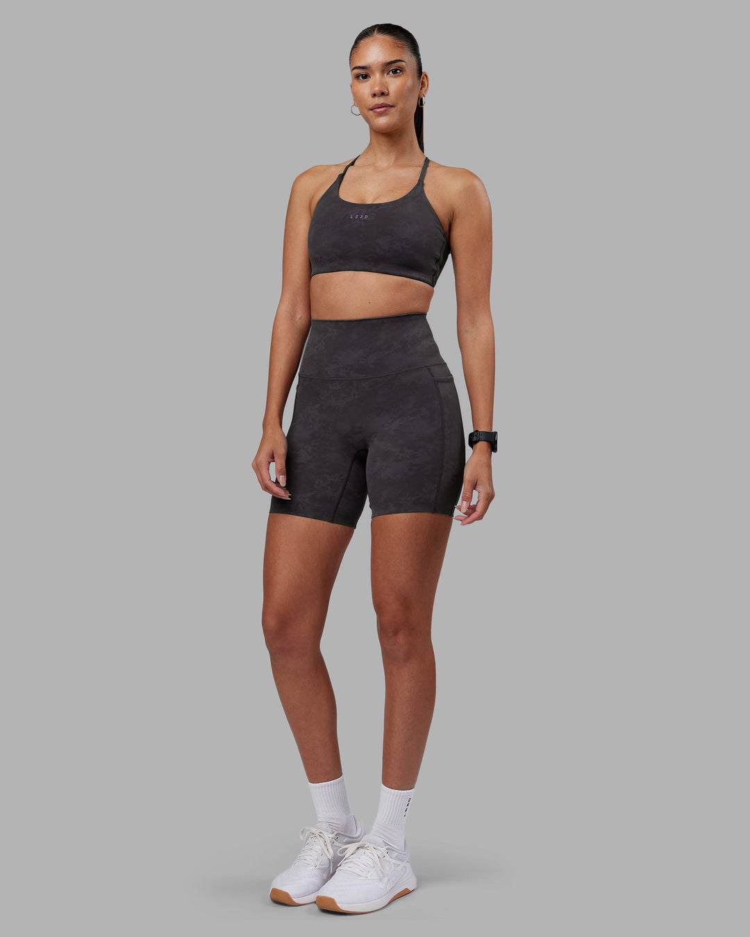 Woman wearing Twist Sports Bra - Dark Storm Wash | Model:Rhiley | Size:S