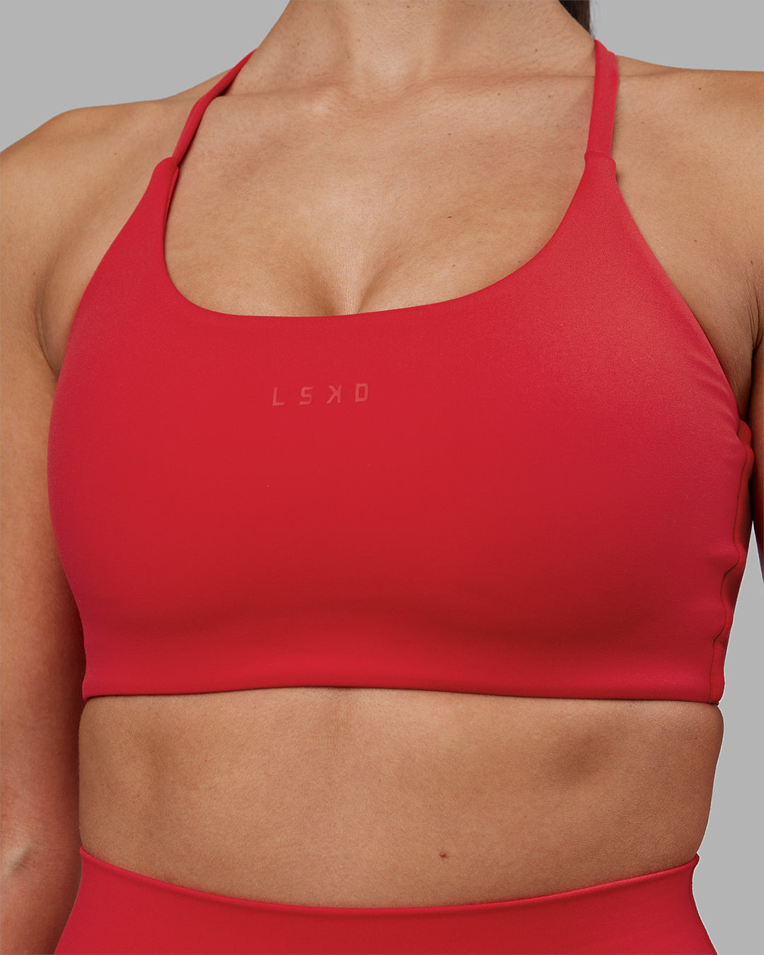 Woman wearing Twist Sports Bra - Scarlet | Model:Rhiley | Size:S