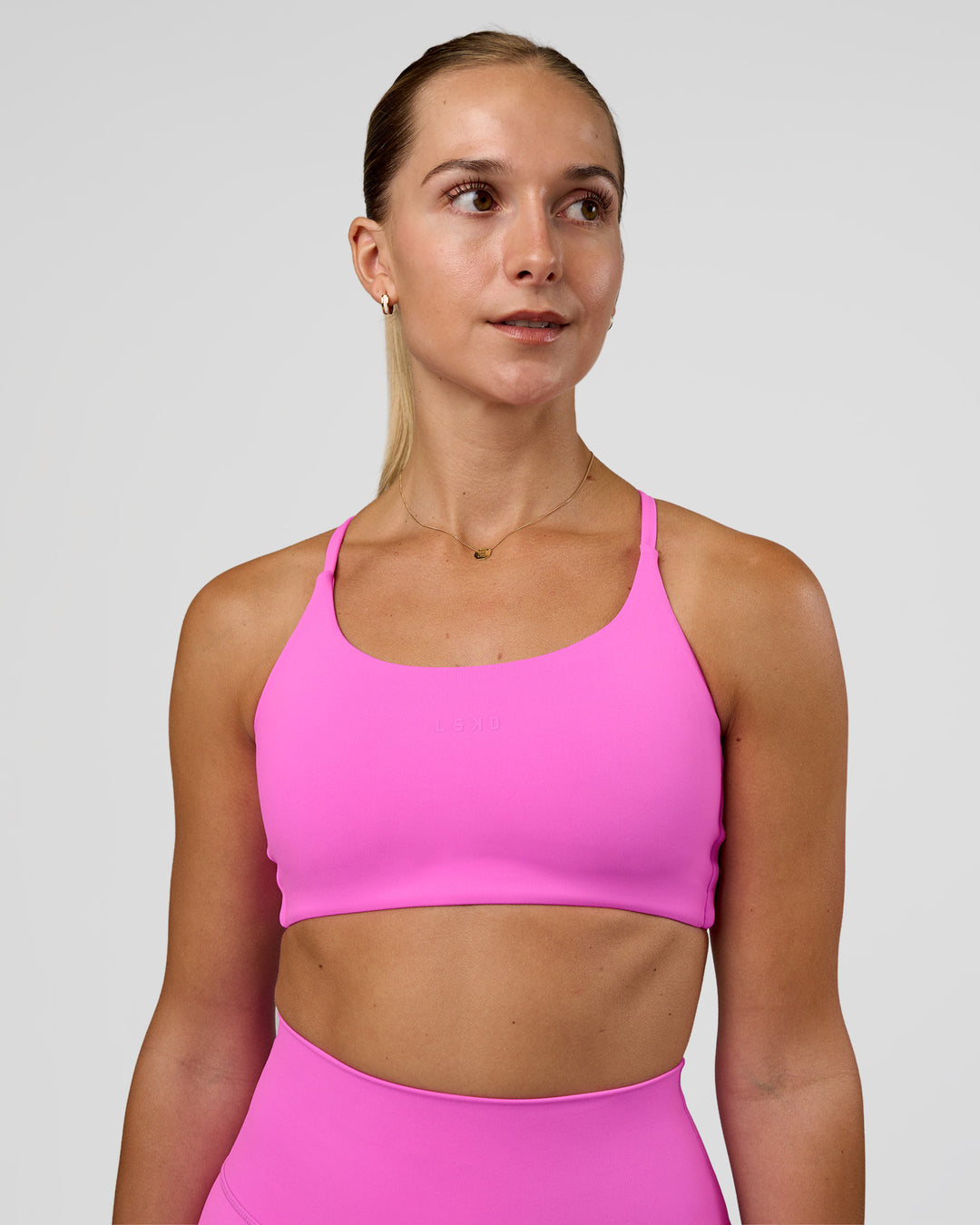Woman wearing Twist Sports Bra - Ultra Fuchsia | Model:Myrte | Size:S
