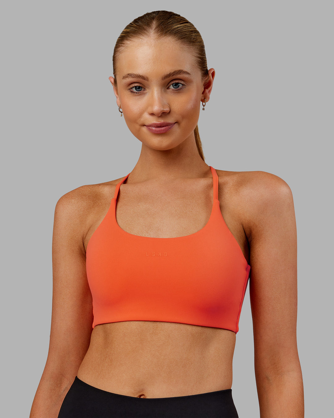Woman wearing Twist Sports Bra - Ultra Orange | Model:Ella | Size:S