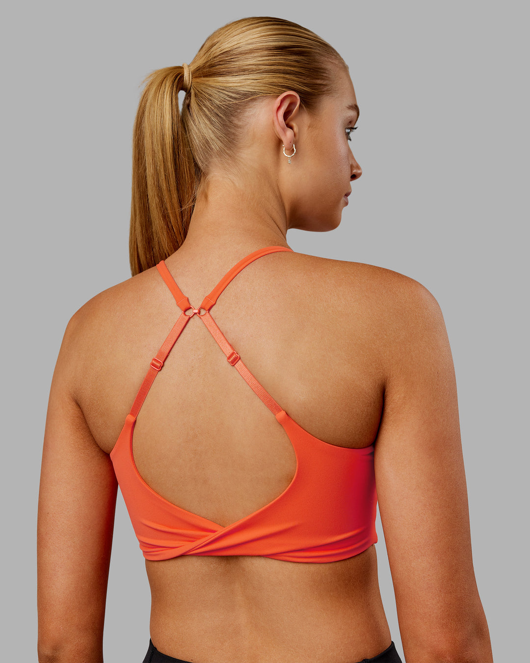 Woman wearing Twist Sports Bra - Ultra Orange | Model:Ella | Size:S