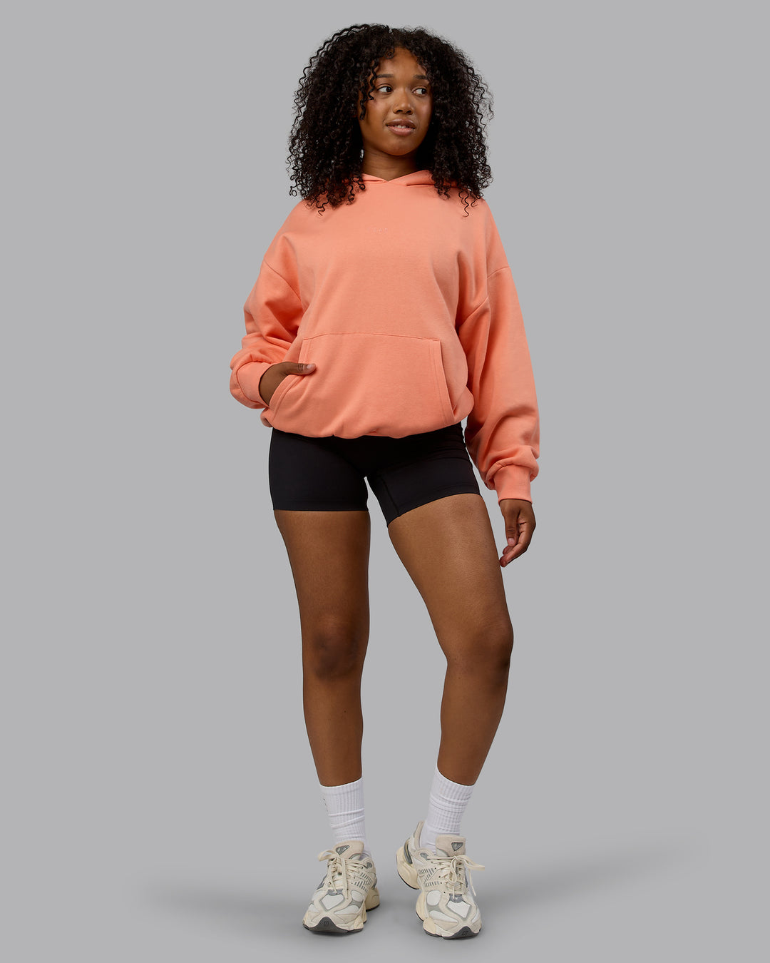 Woman wearing Unisex MVP Hoodie Oversize - Mellow Peach