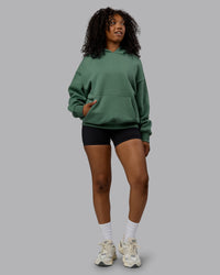 Woman wearing Unisex MVP Hoodie Oversize - Sage Brush