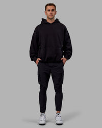 Man wearing Unisex We Rise Hoodie Oversize - Black-Impact Green