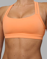 Woman wearing Velocity Sports Bra - Cantaloupe | Model:Hannah | Size:S