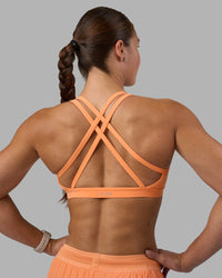 Woman wearing Velocity Sports Bra - Cantaloupe | Model:Hannah | Size:S