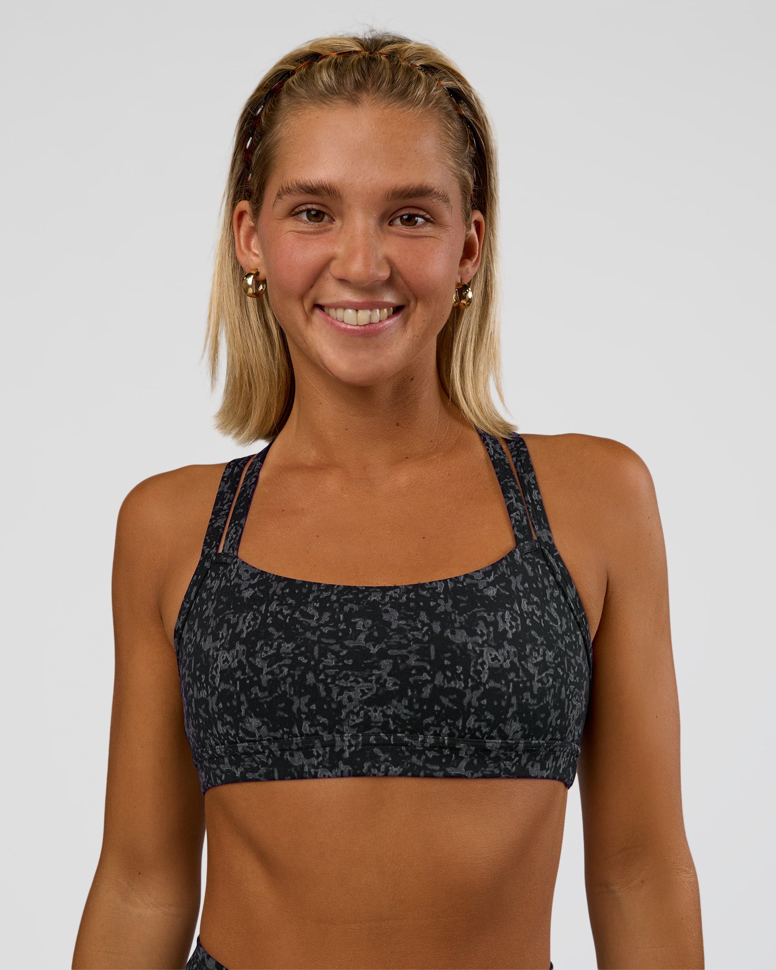 Woman wearing Velocity Sports Bra - Energy Print Black | Model:Amity | Size:S