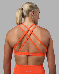 Woman wearing Velocity Sports Bra - Ultra Orange | Model:Katie | Size:S